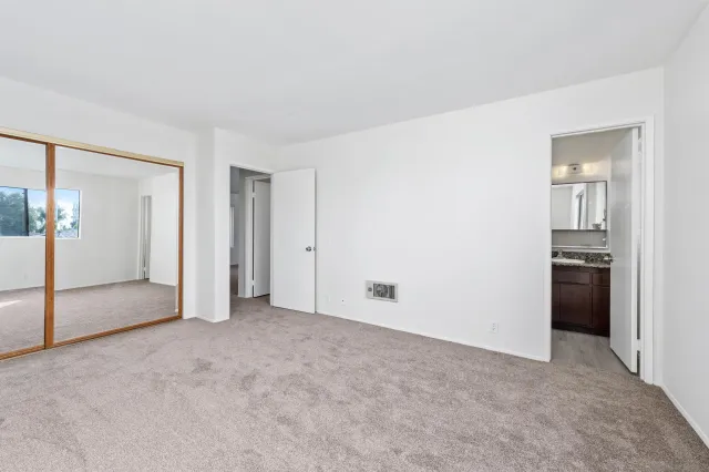 an empty room with closet and a bathroom