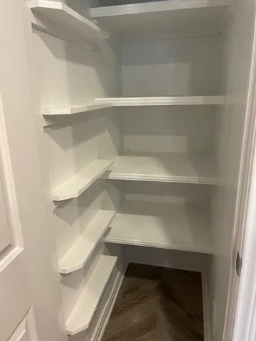a view of walk in closet with empty racks