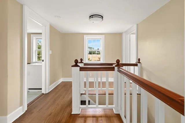 a view of a hallway with wooden floor and staircase
