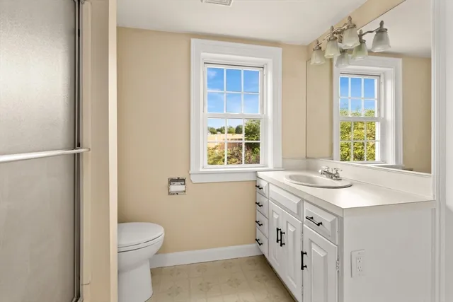 a bathroom with a granite countertop sink and a window
