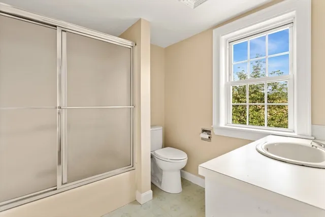 a bathroom with a sink a toilet and shower