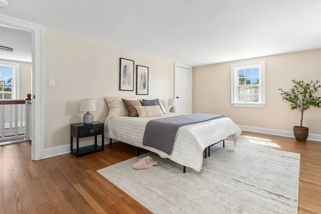 a spacious bedroom with a bed and wooden floor