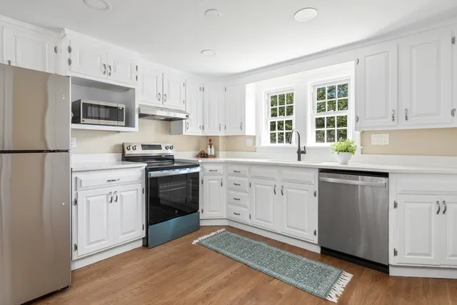 a kitchen with granite countertop white cabinets and white appliances