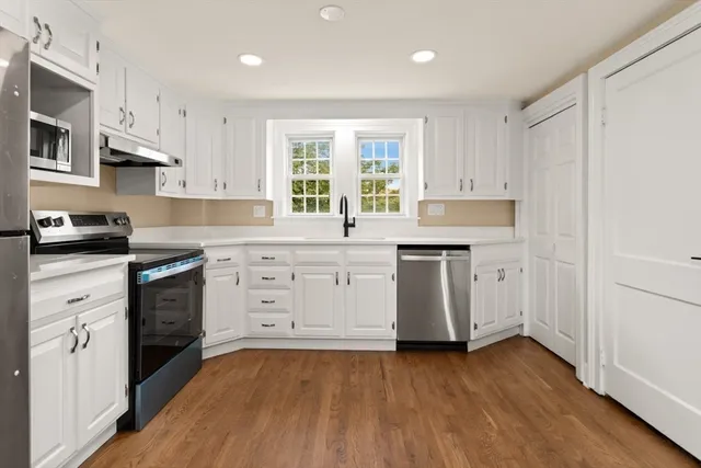 a kitchen with stainless steel appliances a white stove top oven sink and cabinets
