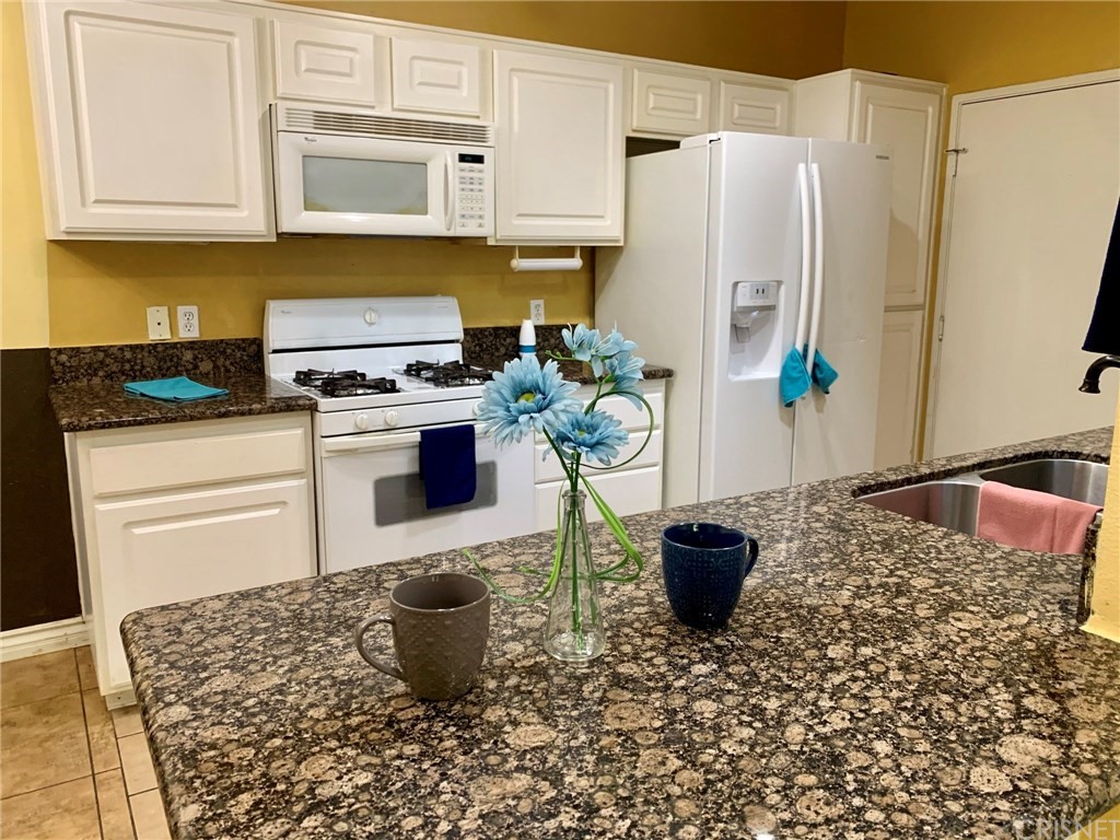 20000 Plum Canyon Road, Unit 1415 Saugus, CA 91350 - Photo 1 of 1 a kitchen with a stove a sink and a refrigerator
