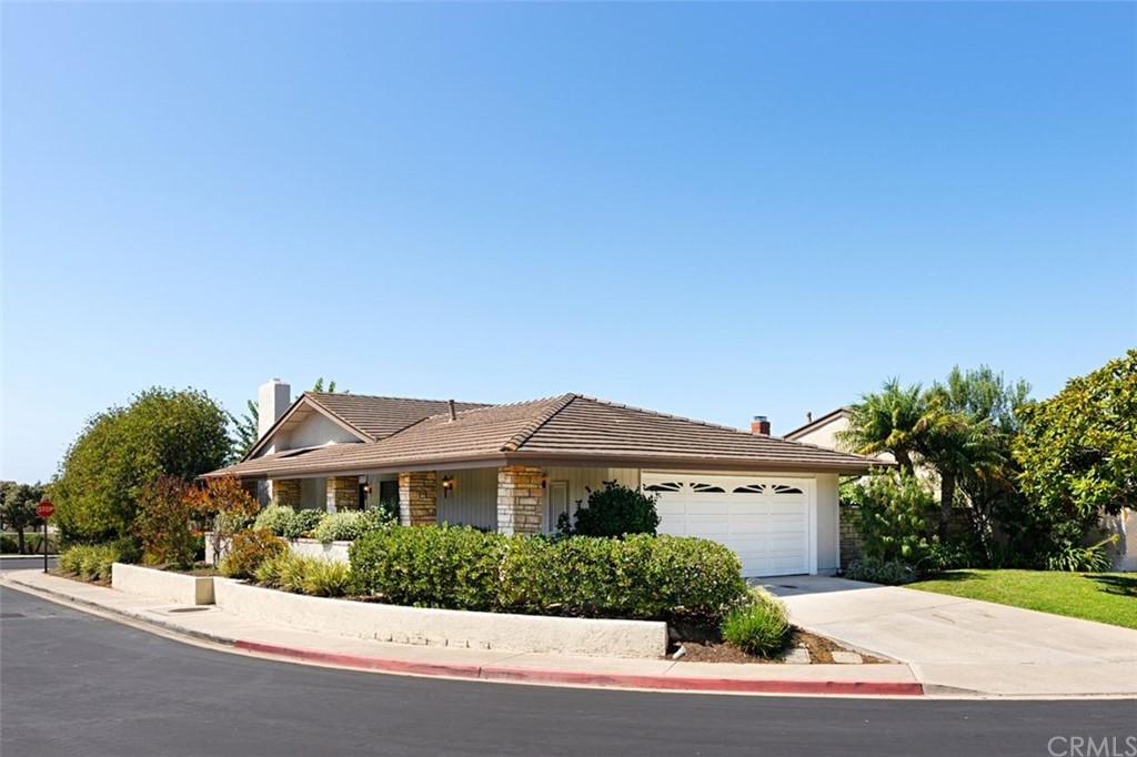 a front view of a house with a yard and potted plants