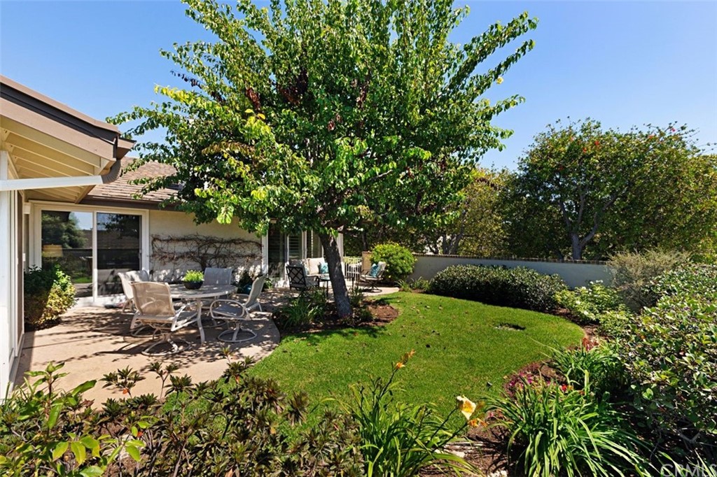11 Jetty Drive Corona del Mar, CA 92625 - Photo 31 of 44 a view of a patio with table and chairs potted plants and large tree