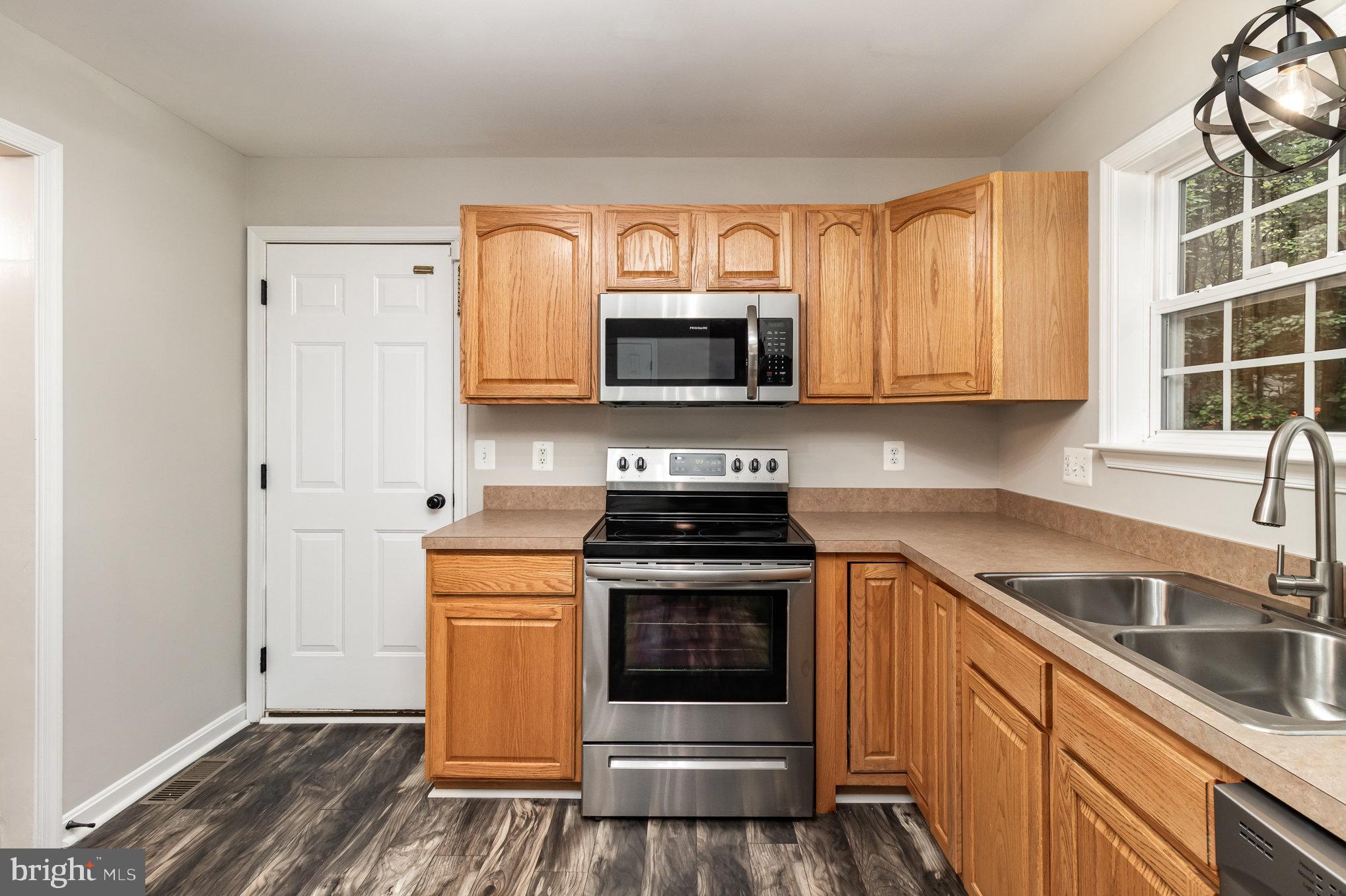 3605 Burton Road Bumpass, VA 23024 - Photo 17 of 44 a kitchen with granite countertop a stove top oven microwave and cabinets