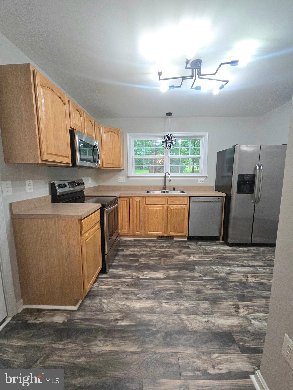 3605 Burton Road Bumpass, VA 23024 - Photo 18 of 44 a large kitchen with granite countertop a stove top oven a sink dishwasher a dining table and chairs with wooden floor