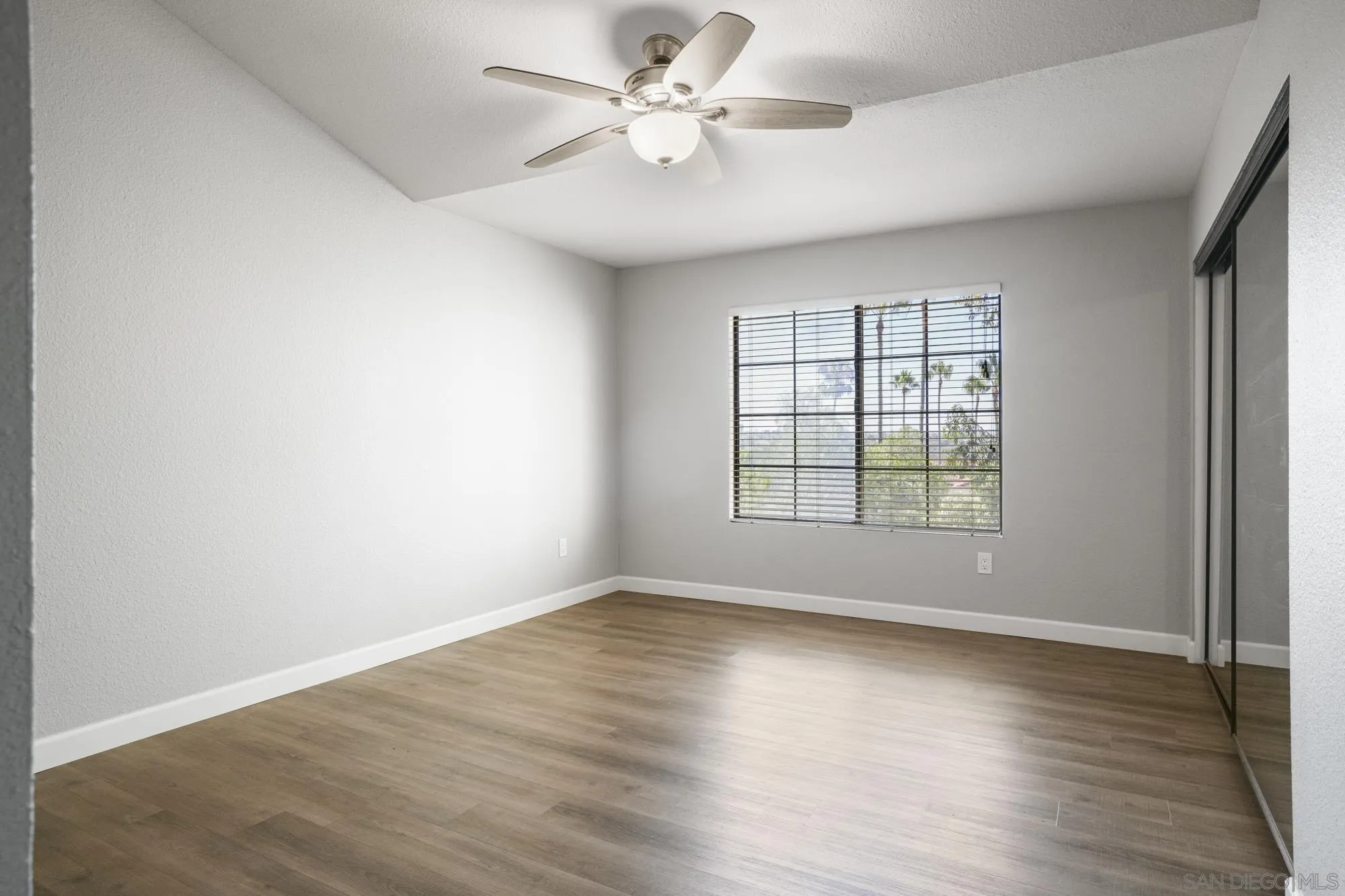 7347 Paseo Verde Carlsbad, CA 92009 - Photo 11 of 27 an empty room with wooden floor and windows