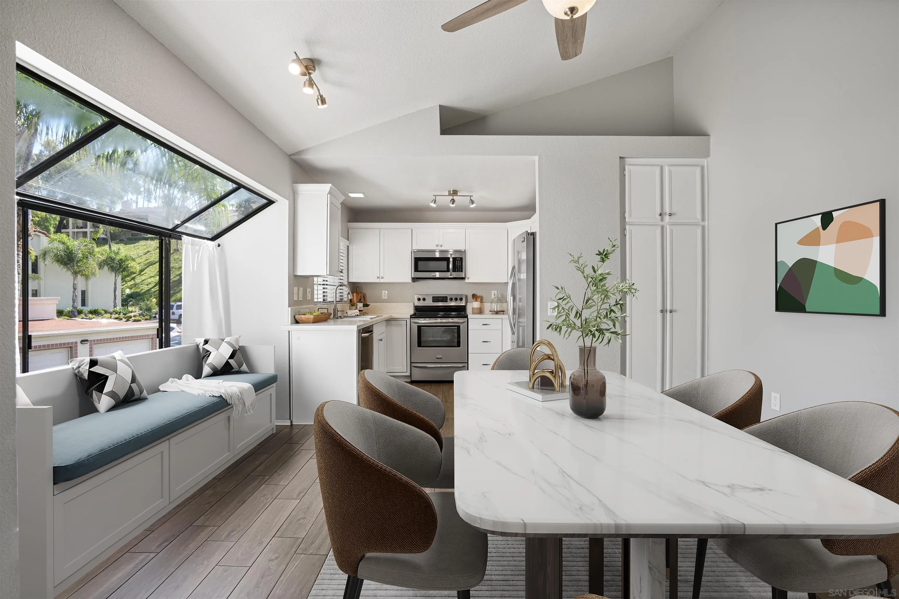 7347 Paseo Verde Carlsbad, CA 92009 - Photo 3 of 27 a kitchen with stainless steel appliances kitchen island granite countertop a dining table chairs sink and white cabinets