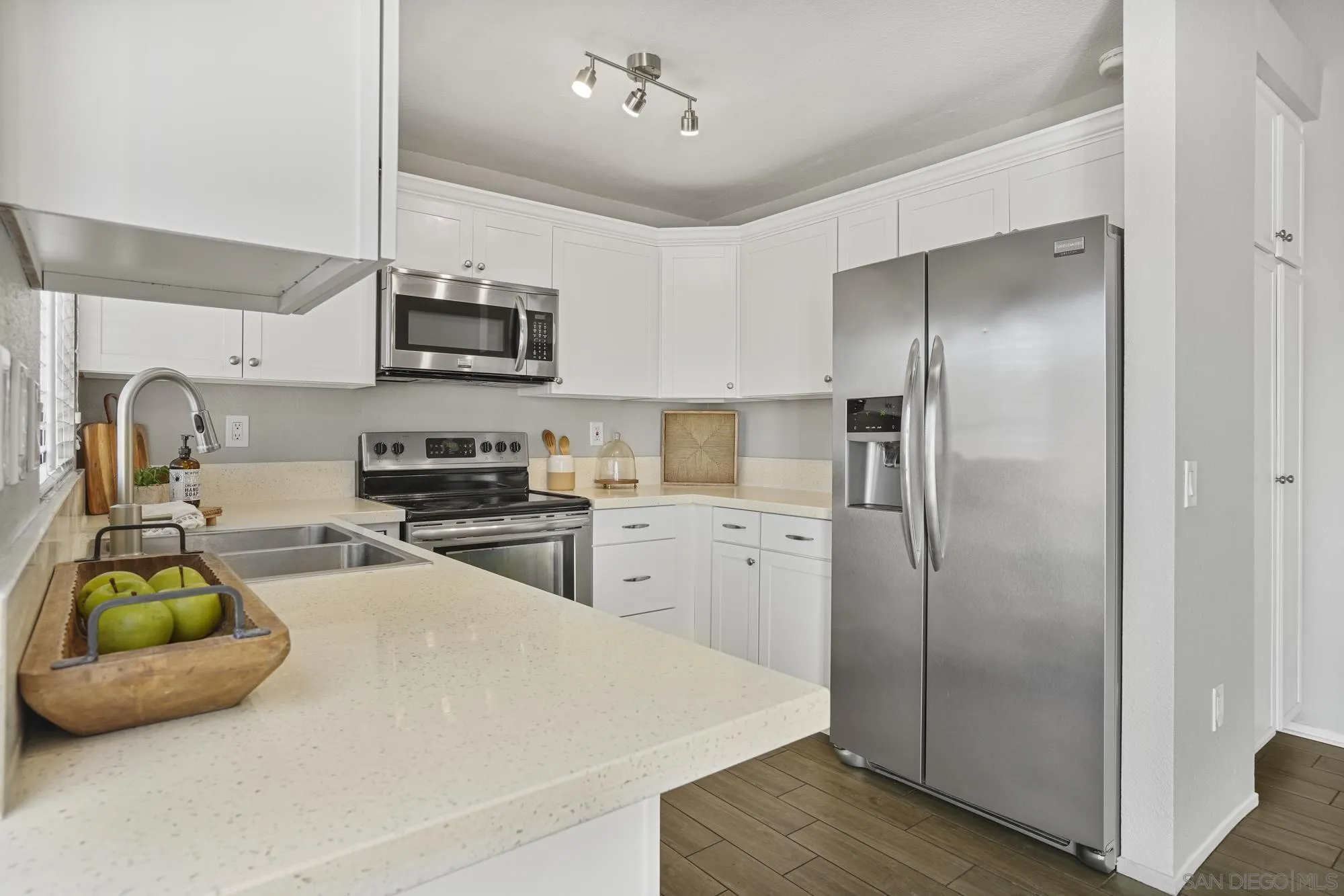 7347 Paseo Verde Carlsbad, CA 92009 - Photo 6 of 27 a kitchen with stainless steel appliances a refrigerator sink and wooden floor