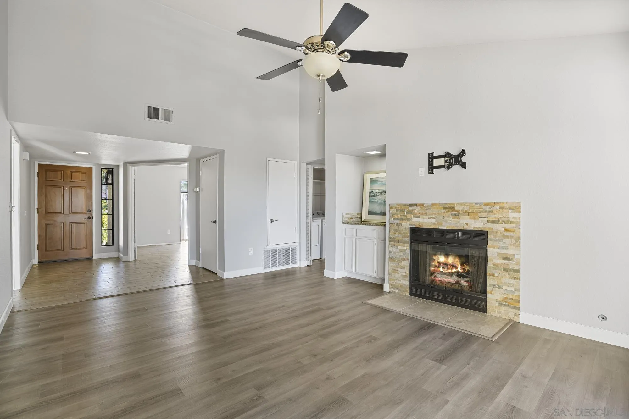 7347 Paseo Verde Carlsbad, CA 92009 - Photo 9 of 27 a view of an empty room with wooden floor a fireplace and a window