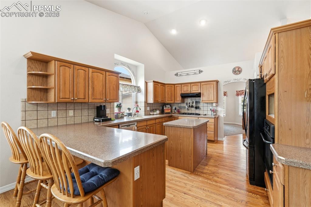 16261 Hobson Place Monument, CO 80132 - Photo 15 of 50 a kitchen with a table chairs refrigerator and cabinets