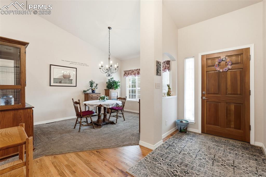 16261 Hobson Place Monument, CO 80132 - Photo 8 of 50 a dining room with furniture a chandelier and wooden floor
