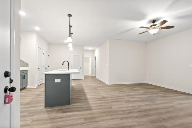 a view of a kitchen with wooden floor and a ceiling fan