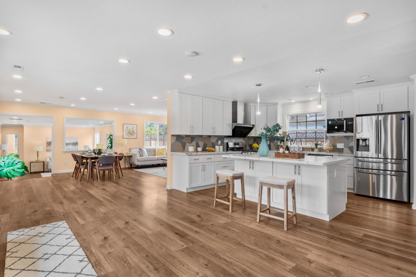 983 Smith Avenue Campbell, CA 95008 - Photo 8 of 57 a kitchen with stainless steel appliances granite countertop a refrigerator a stove a sink a dining table and chairs with wooden floor