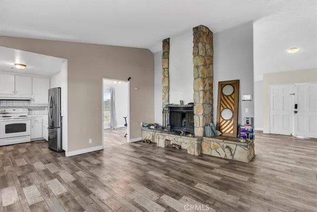 a living room with furniture a fireplace and kitchen view