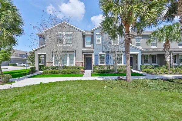 a front view of a house with a yard and palm trees