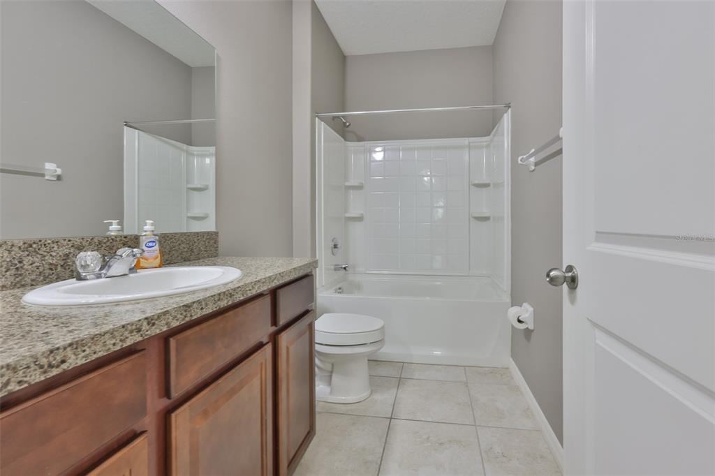 6330 Lantern View Place Apollo Beach, FL 33572 - Photo 17 of 64 a bathroom with a granite countertop sink toilet and shower