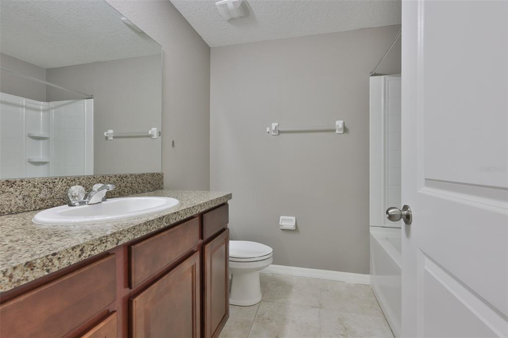 6330 Lantern View Place Apollo Beach, FL 33572 - Photo 31 of 64 a bathroom with a granite countertop sink a toilet and a mirror