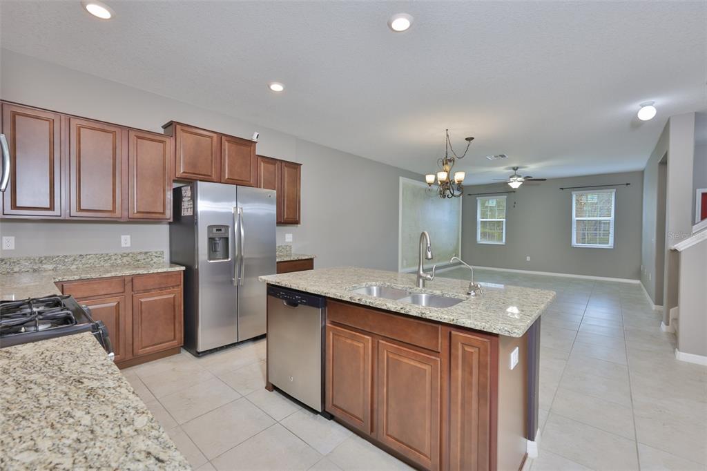 6330 Lantern View Place Apollo Beach, FL 33572 - Photo 10 of 64 a kitchen with stainless steel appliances granite countertop a sink stove and refrigerator