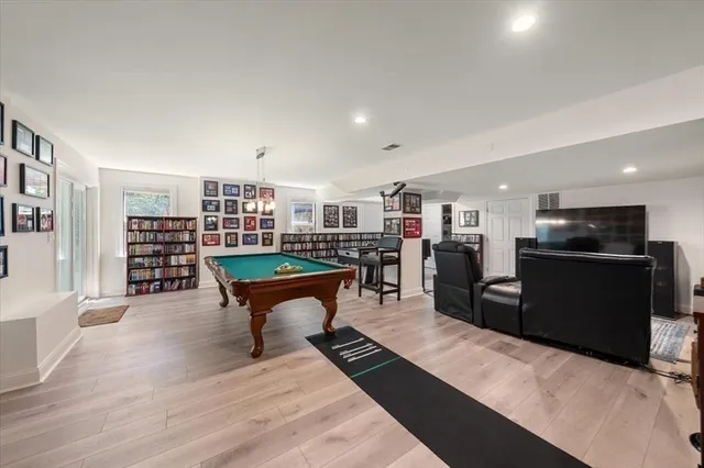 a living room with furniture a flat screen tv and kitchen view