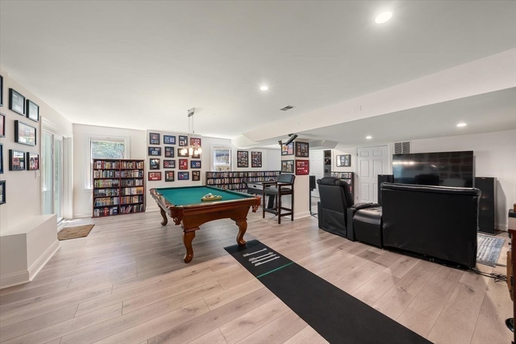 15 A Moccasin Path Natick, MA 01760 - Photo 21 of 42 a living room with furniture a flat screen tv and kitchen view