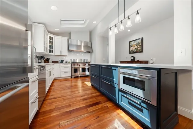 a kitchen with stainless steel appliances a stove top oven and refrigerator