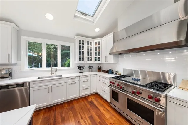 a large kitchen with stainless steel appliances granite countertop a stove and a sink