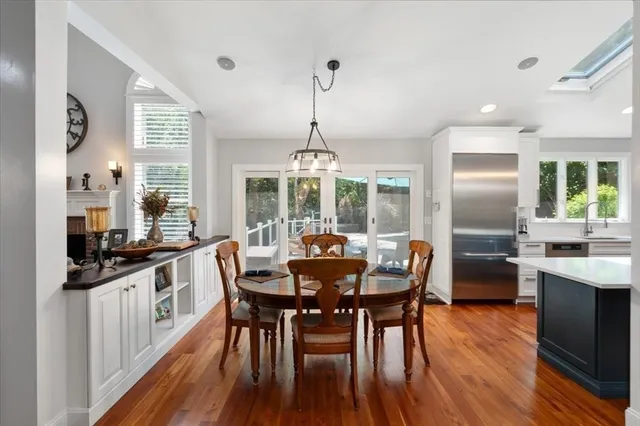 a kitchen with stainless steel appliances granite countertop a dining table chairs stove and refrigerator