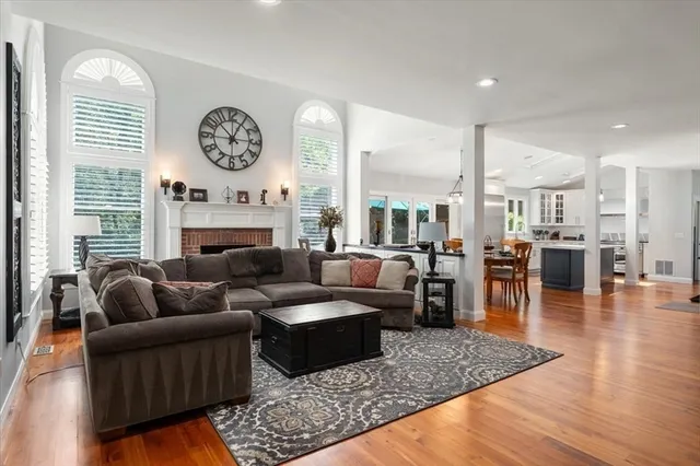 a living room with furniture kitchen view and a large window