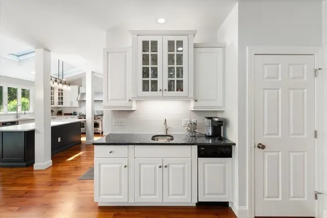 a kitchen with stainless steel appliances granite countertop a stove a sink and white cabinets