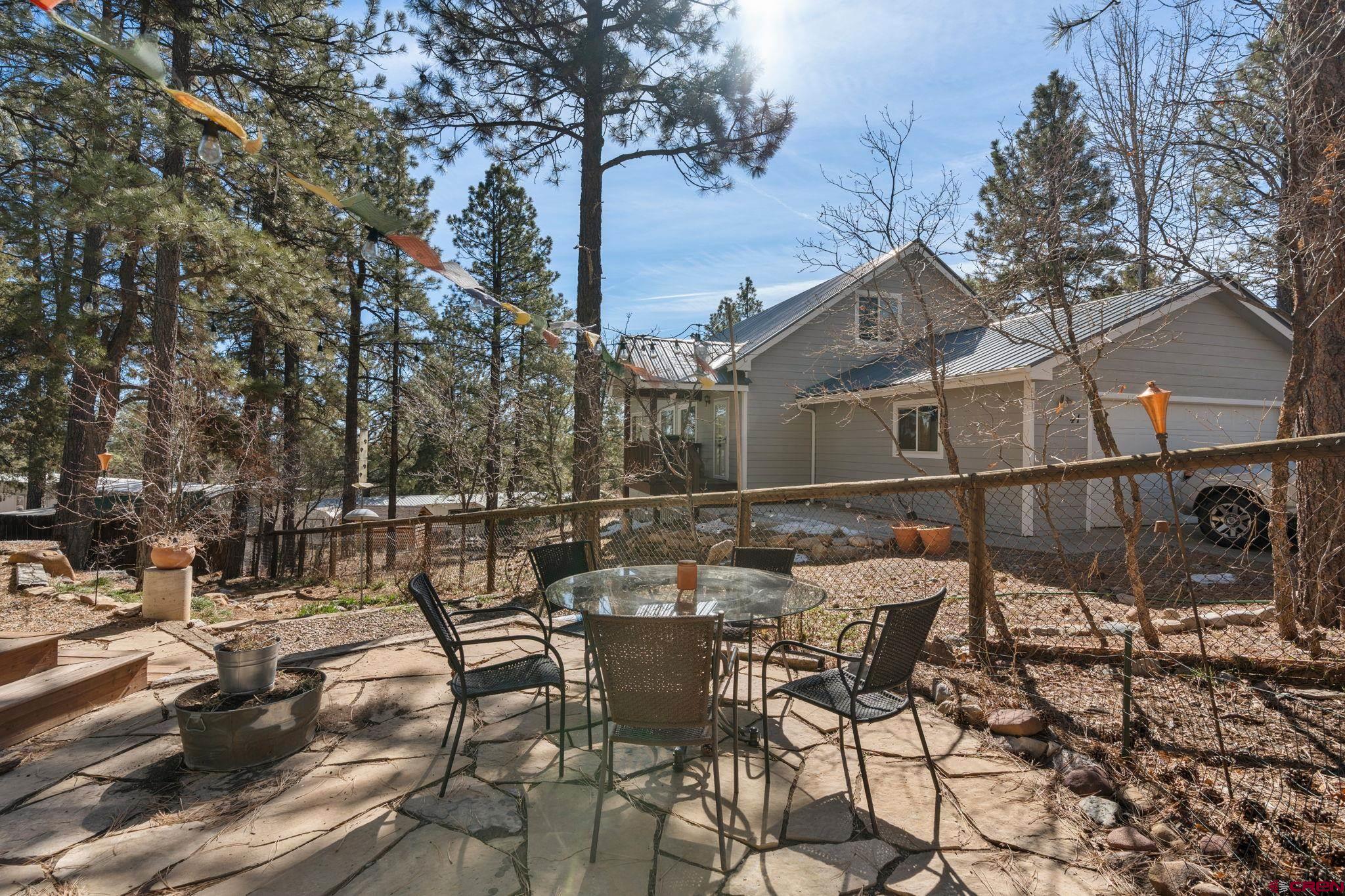 31 Valley View Way Durango, CO 81303 - Photo 26 of 29 a view of a patio with table and chairs and potted plants with wooden fence