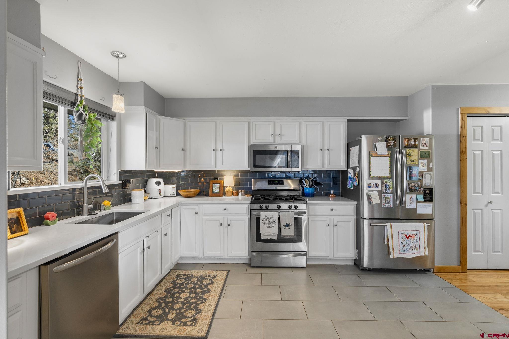 31 Valley View Way Durango, CO 81303 - Photo 8 of 29 a kitchen with stainless steel appliances a sink a stove a refrigerator cabinets and a window