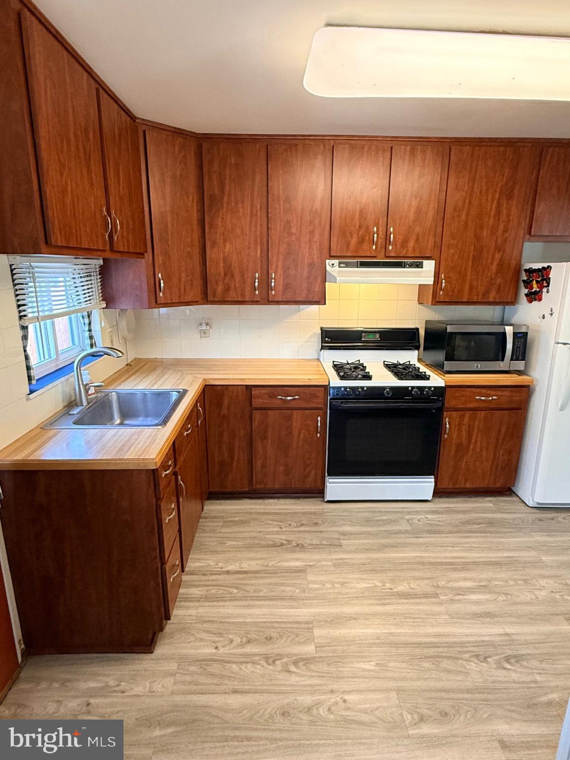 1446 Fitzwatertown Road Willow Grove, PA 19090 - Photo 8 of 19 a kitchen with wooden cabinets and a sink