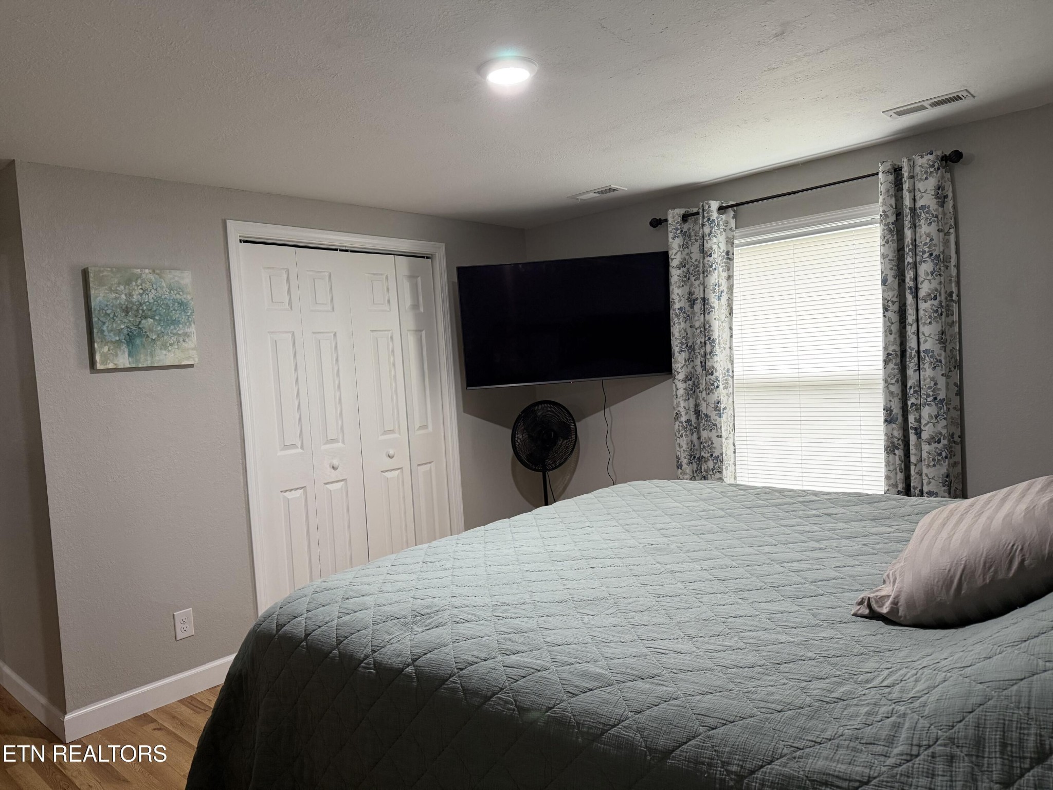 309 Hobson Road Kingston, TN 37763 - Photo 9 of 12 a bedroom with a bed and a flat tv screen on wall