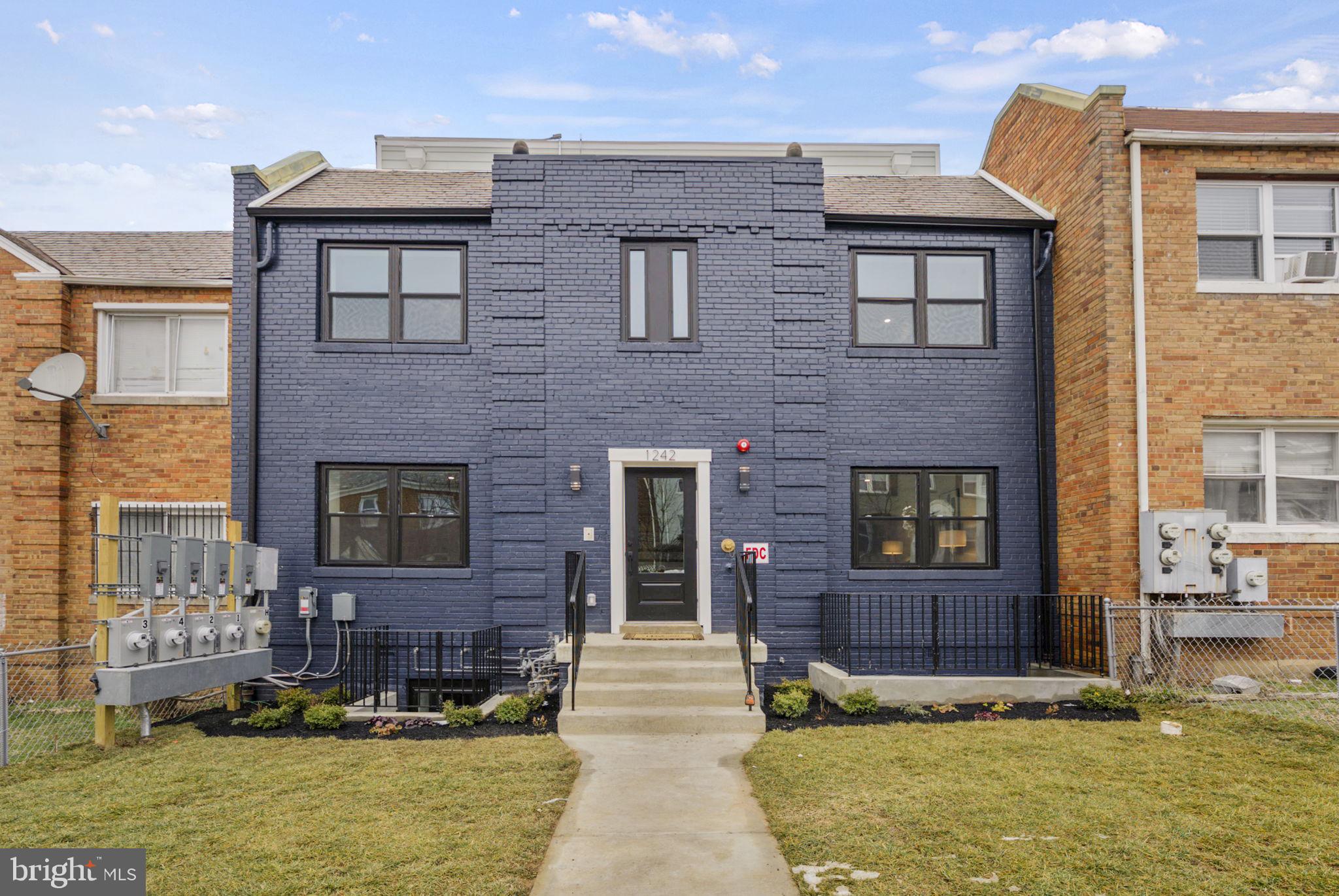 1242 Meigs Place Northeast, Unit 3 Washington, DC 20002 - Photo 1 of 13 a front view of a house with a yard