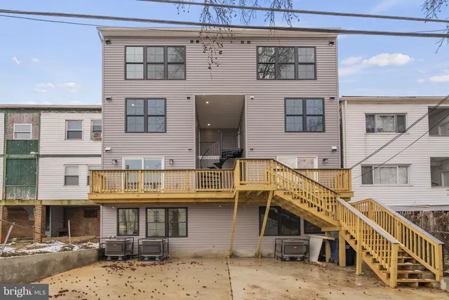 a front view of a building with streets and trees