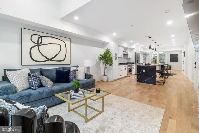 a living room with furniture a fireplace and a chandelier