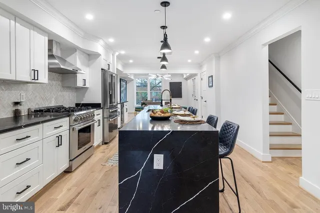 a kitchen with a table chairs refrigerator and cabinets