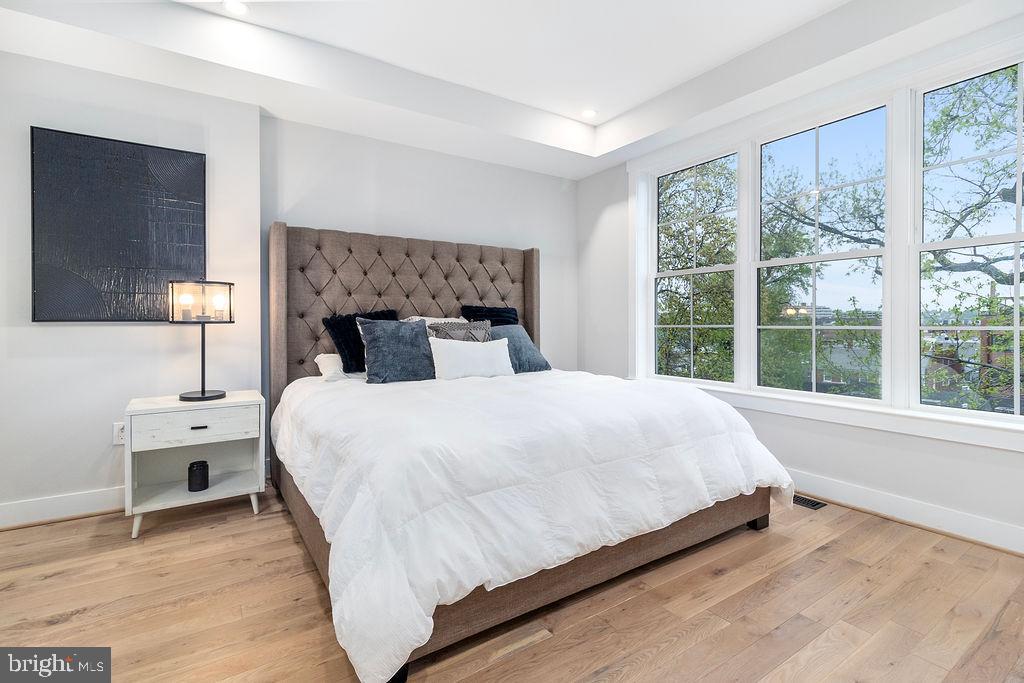 1242 Meigs Place Northeast, Unit 3 Washington, DC 20002 - Photo 9 of 13 a large bed sitting in a bedroom next to a window