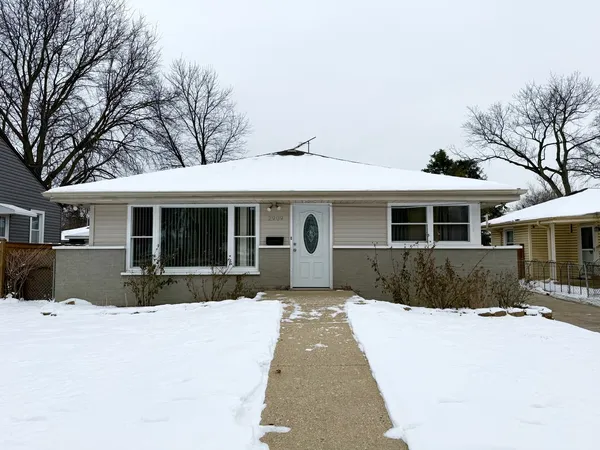 a front view of a house with a garden and trees