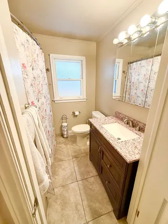 a bathroom with a granite countertop sink and a large mirror