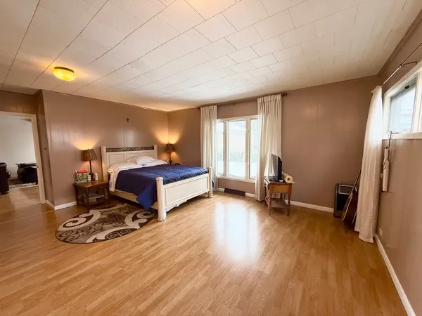 a bedroom with a bed and a large window