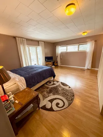 a bedroom with a bed and wooden floor