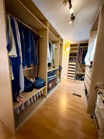 a view of walk in closet with clothes and shoes