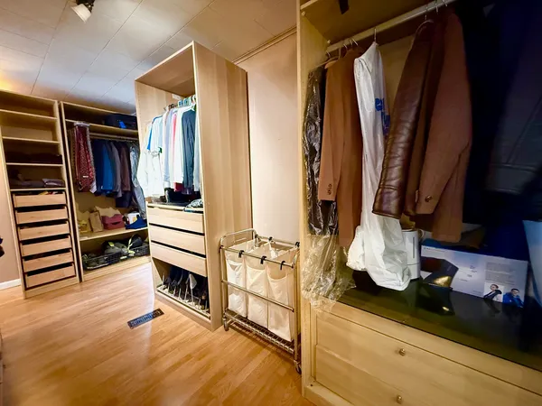 a view of walk in closet with clothes and shoes