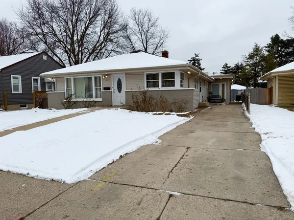 a front view of a house with a yard covered with trees