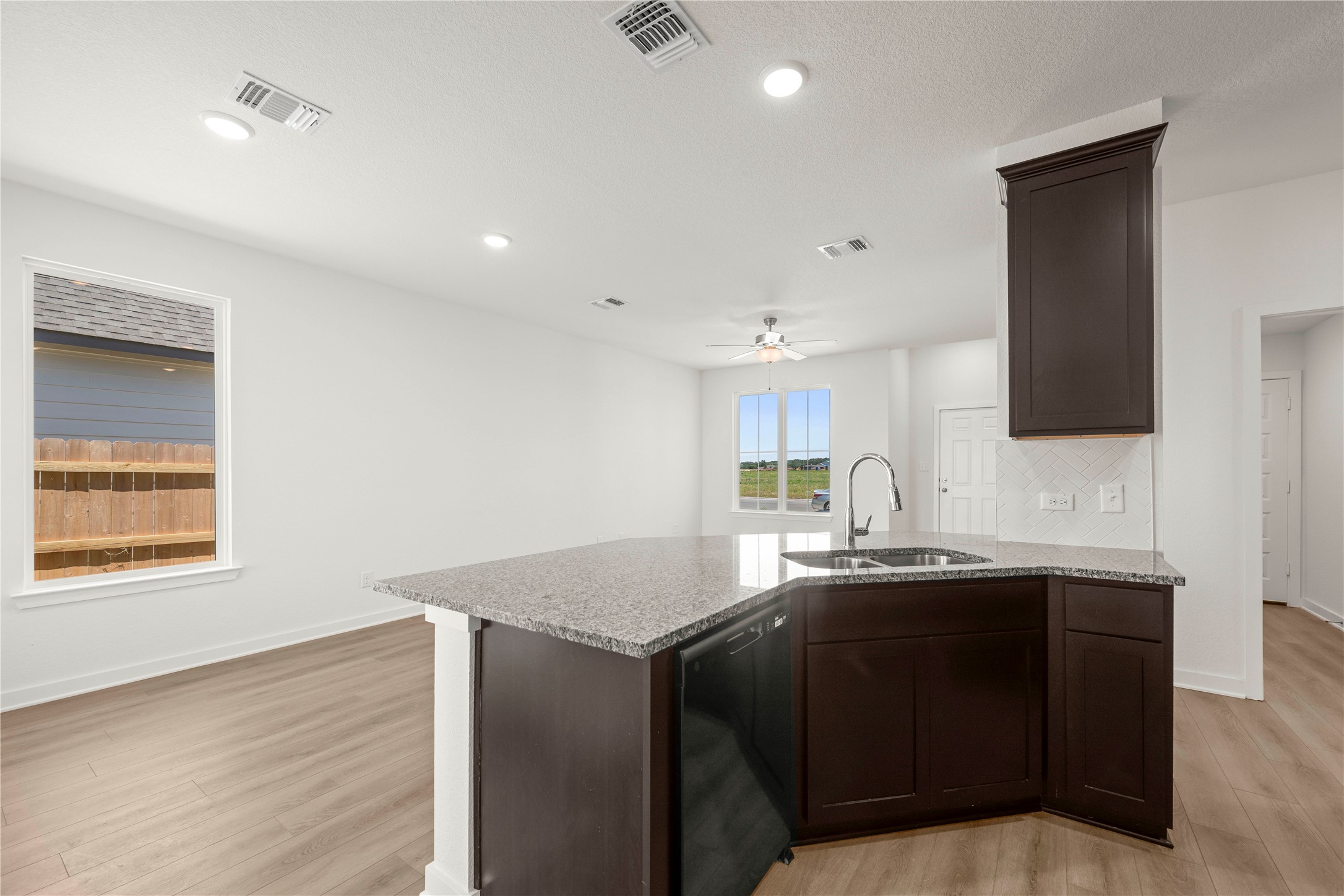 228 Gus Loop Georgetown, TX 78626 - Photo 16 of 19 A contemporary kitchen island boasts granite counters and integrated appliances, providing both style and function.